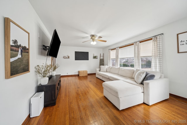 living room featuring ceiling fan, wood finished floors, and baseboards