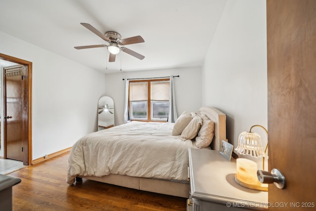 bedroom featuring ceiling fan, wood finished floors, and baseboards