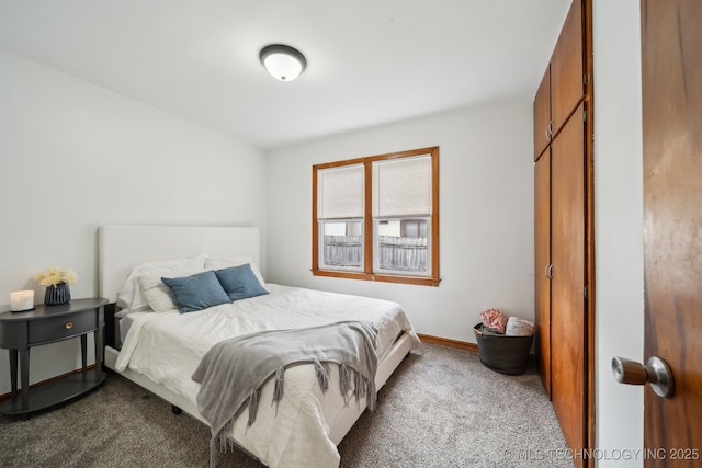 bedroom with baseboards and dark colored carpet