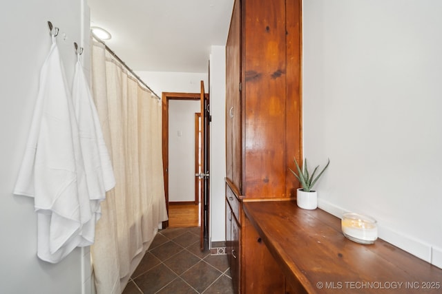 hallway with dark tile patterned floors