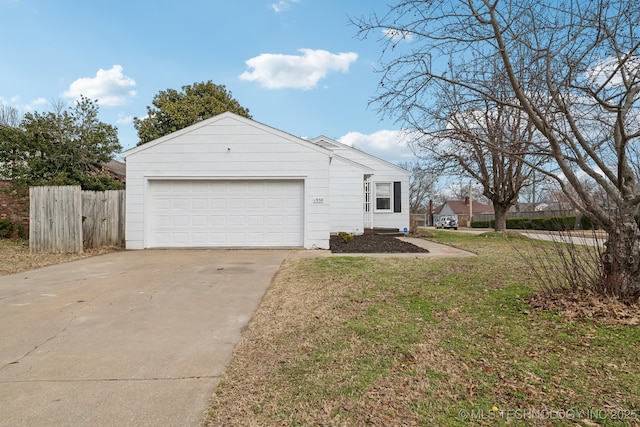 view of side of home with a garage, fence, driveway, and a lawn