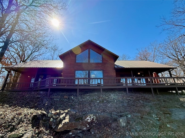 back of property featuring metal roof and a wooden deck