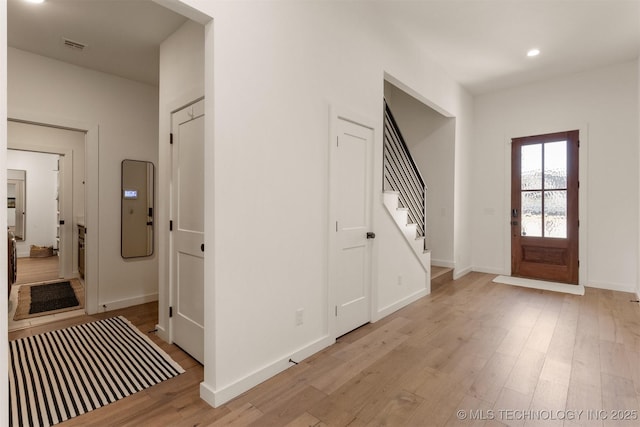 foyer with light wood-style flooring, stairway, baseboards, and recessed lighting