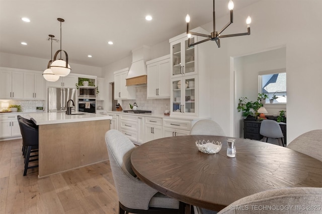 dining area with light wood finished floors and recessed lighting