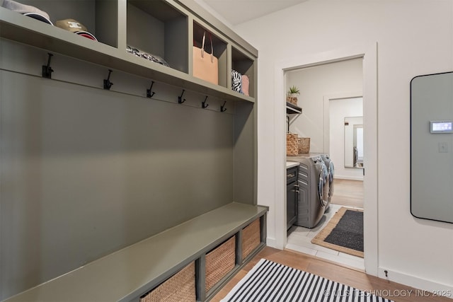 mudroom with light wood-type flooring and washer and dryer