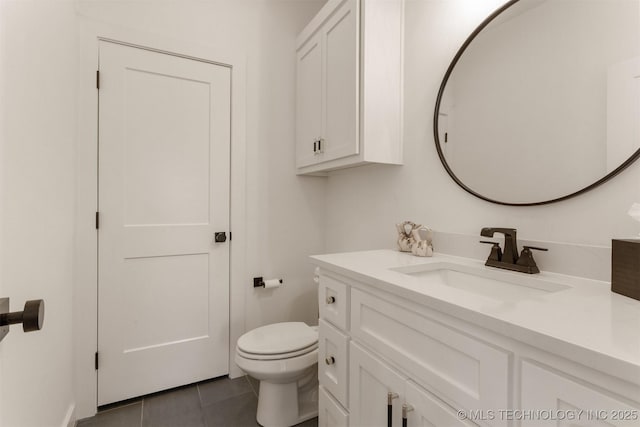 bathroom with toilet, tile patterned flooring, and vanity