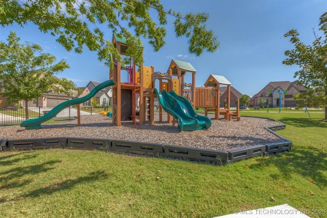 communal playground featuring fence and a lawn