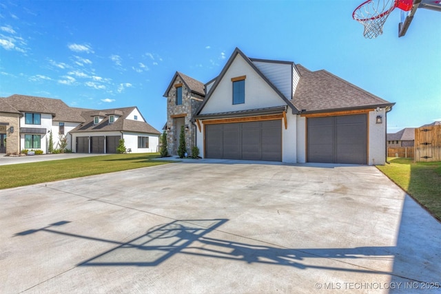 view of front of house featuring brick siding, a shingled roof, concrete driveway, stone siding, and a front yard