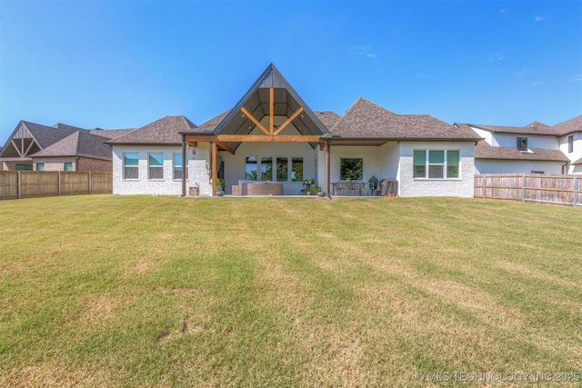 back of house featuring a fenced backyard, a lawn, and a patio