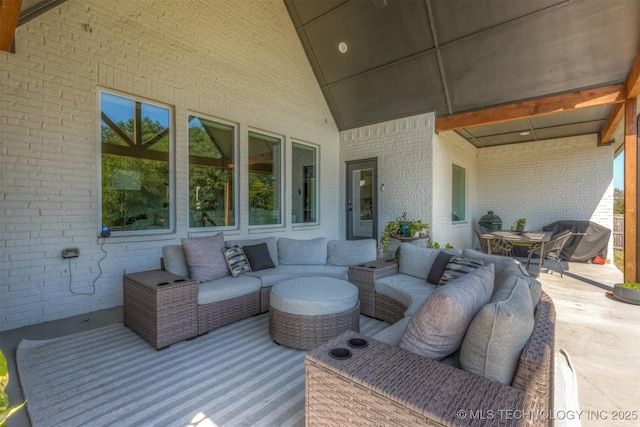 wooden deck featuring a grill, an outdoor living space, and a patio