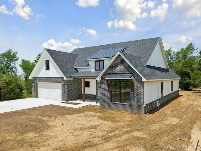 modern inspired farmhouse with driveway, a standing seam roof, metal roof, and brick siding