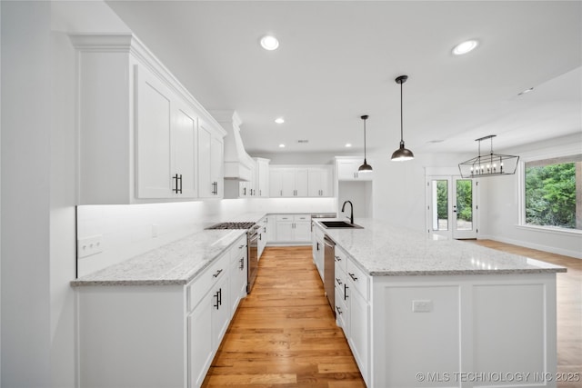 kitchen with recessed lighting, custom range hood, backsplash, appliances with stainless steel finishes, and a sink