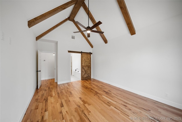 unfurnished living room featuring high vaulted ceiling, a barn door, visible vents, light wood-style floors, and beam ceiling