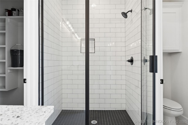 bathroom with a shower stall and toilet