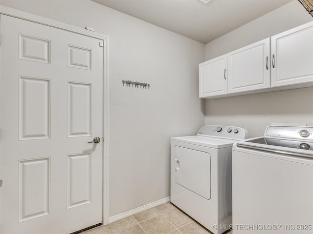 laundry area featuring washing machine and clothes dryer, cabinet space, and baseboards