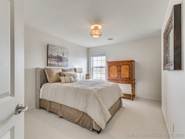 bedroom with baseboards, visible vents, and light colored carpet