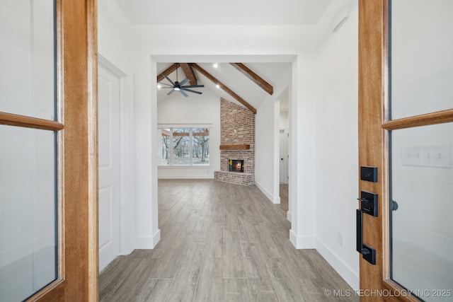 hallway with high vaulted ceiling, baseboards, beam ceiling, and wood finished floors