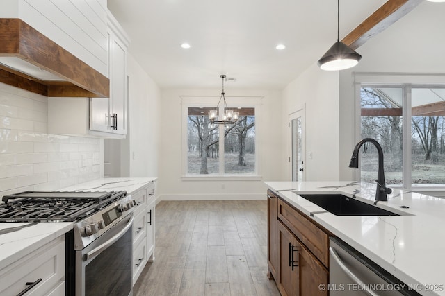 kitchen with light wood-style flooring, stainless steel appliances, premium range hood, a sink, and tasteful backsplash