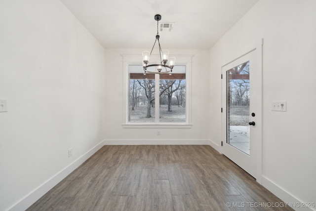 unfurnished dining area with dark wood-style floors, a wealth of natural light, and baseboards