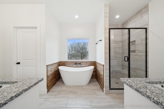 bathroom with wainscoting, vanity, and a shower stall