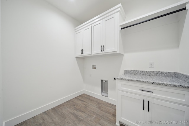 washroom featuring hookup for a washing machine, light wood-style flooring, baseboards, cabinet space, and electric dryer hookup