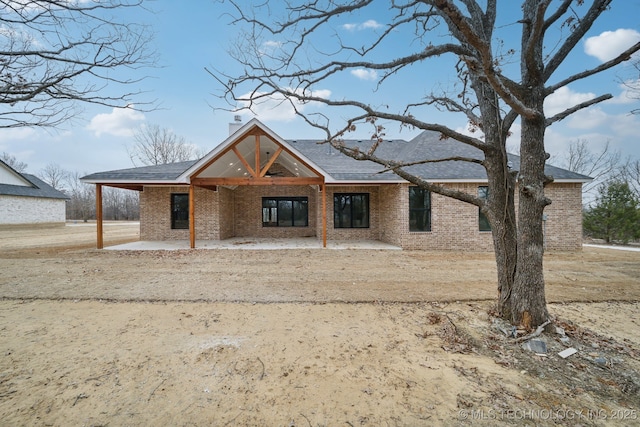 property under construction with a chimney and brick siding