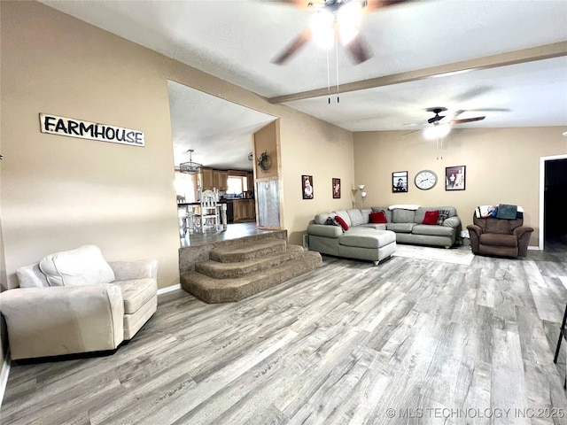 living room with vaulted ceiling with beams, wood finished floors, a ceiling fan, and baseboards