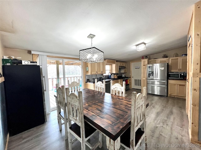 dining room featuring vaulted ceiling and light wood-type flooring