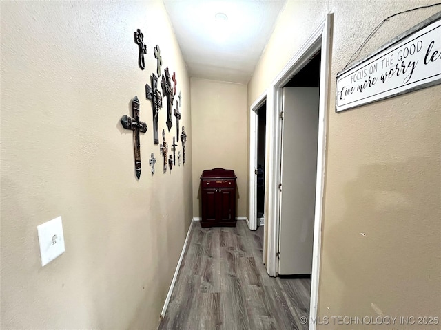 hall with baseboards and wood finished floors