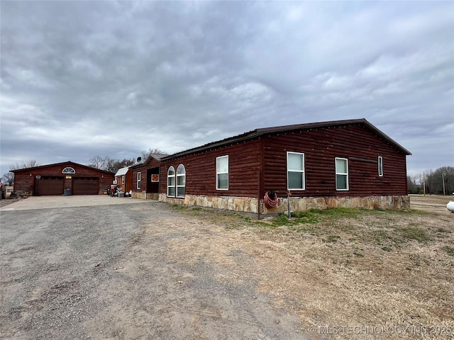 view of side of property featuring an outbuilding and faux log siding