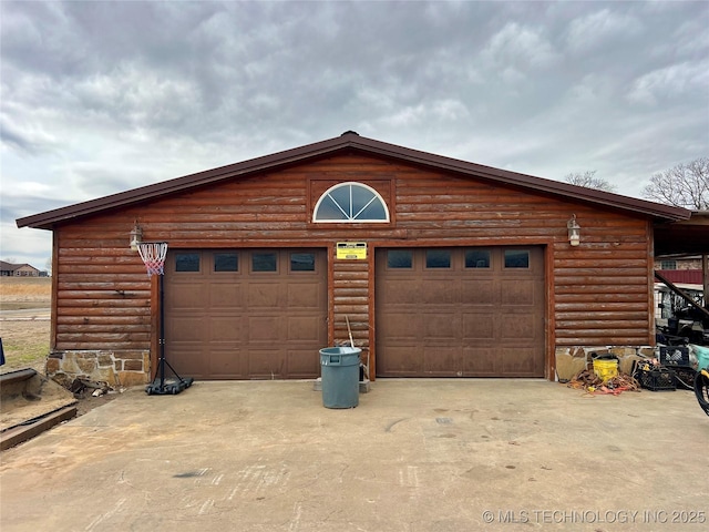 garage featuring concrete driveway