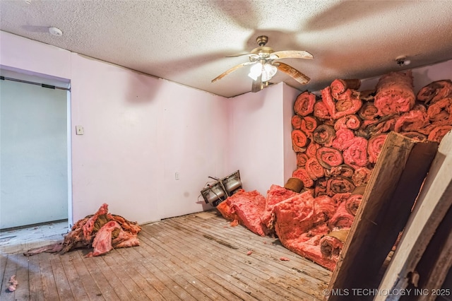 unfurnished bedroom featuring a textured ceiling, hardwood / wood-style floors, and a ceiling fan