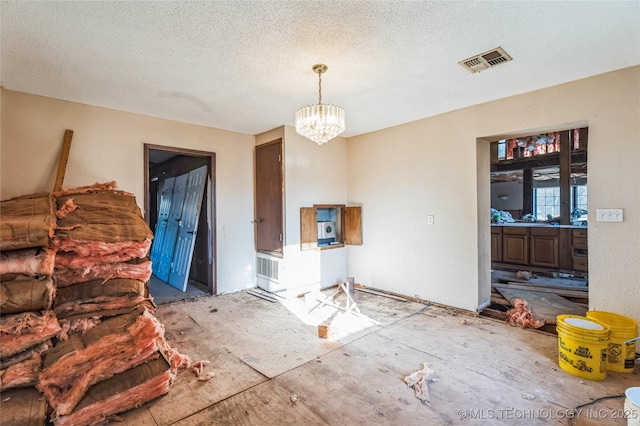 dining space featuring visible vents, a textured ceiling, and an inviting chandelier