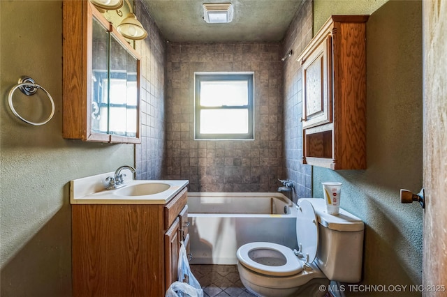 full bath with a textured wall, vanity, a bathtub, and toilet