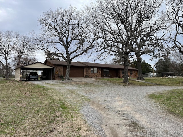 view of front of property featuring driveway, a carport, an attached garage, and brick siding