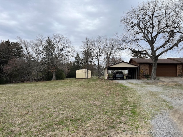 view of yard featuring an outbuilding, driveway, and a storage shed