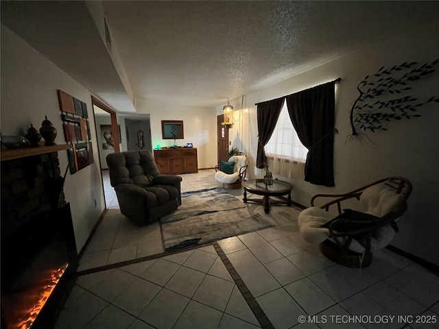 tiled living area with a textured ceiling and baseboards