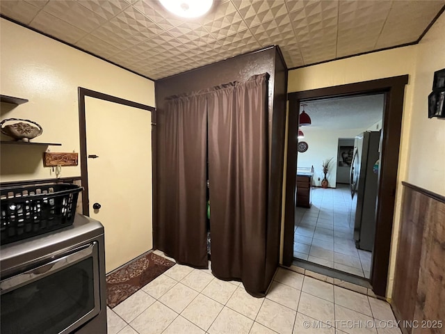 kitchen with light tile patterned floors and freestanding refrigerator