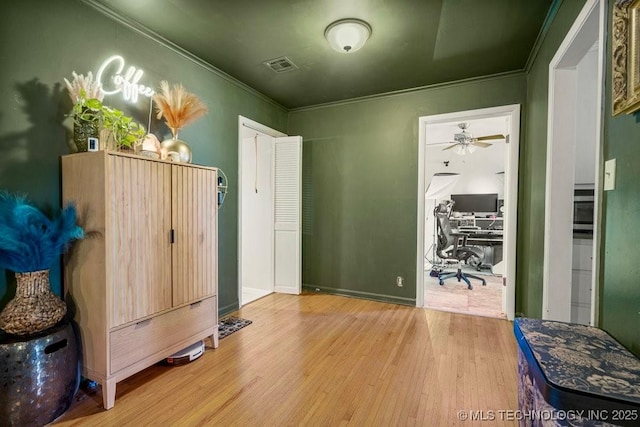 bedroom with ornamental molding, wood finished floors, and visible vents