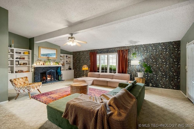 carpeted living room with wallpapered walls, ceiling fan, vaulted ceiling with beams, a textured ceiling, and a fireplace