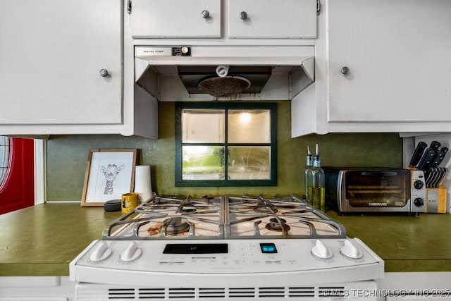 kitchen featuring white range with gas stovetop and under cabinet range hood