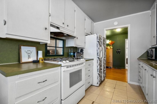 kitchen featuring light tile patterned flooring, under cabinet range hood, white appliances, white cabinets, and dark countertops