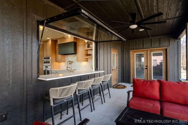 view of patio / terrace featuring outdoor dry bar, french doors, a sink, and an outdoor living space