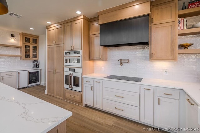 kitchen with wine cooler, white double oven, black electric cooktop, visible vents, and open shelves