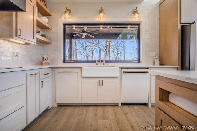 kitchen with light countertops, open shelves, a sink, and light wood-style floors