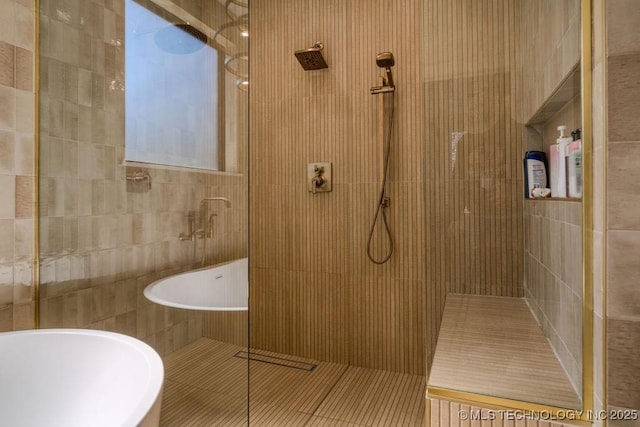 full bath featuring tile patterned flooring, a walk in shower, and tile walls