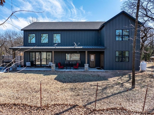 view of front of property with a standing seam roof, metal roof, board and batten siding, and a patio