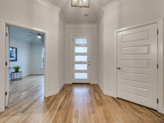 entryway featuring light wood-style flooring, visible vents, baseboards, and crown molding