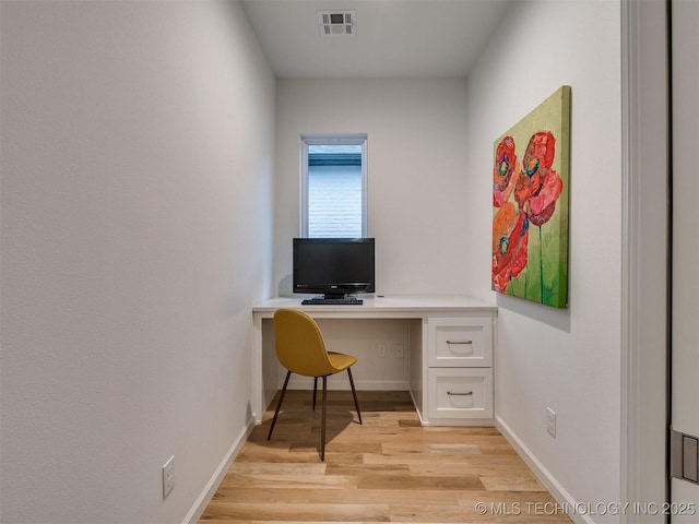 office with light wood finished floors, built in study area, visible vents, and baseboards