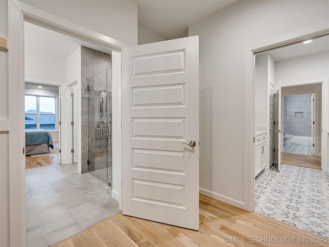 hallway with baseboards and light wood finished floors